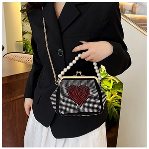 Detail of black rhinestone crossbody bag with red heart pattern and pearl handle