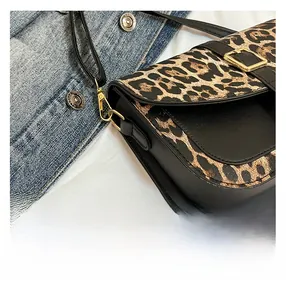 Close-up of leopard print shoulder bag featuring gold buckle and black leather trim