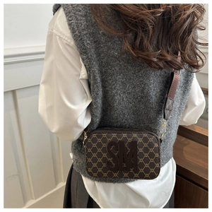 Detail of vintage brown monogram camera bag featuring SM logo and wide adjustable strap