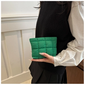 Detail of emerald green quilted pouch with puffer texture and classic grid stitching