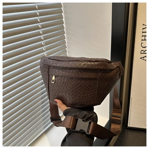 Detailed close-up of dark brown woven chest bag with golden zipper and adjustable nylon strap