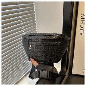 Detail of black woven texture chest bag with double zippers and adjustable strap