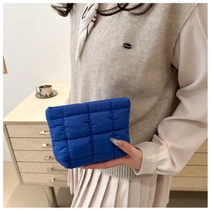Close-up of Klein blue quilted puff clutch bag showing grid stitching and nylon texture