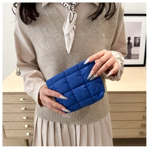 Close-up of klein blue quilted nylon makeup bag with premium stitched square texture