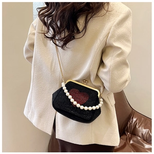 Detail of black rhinestone evening bag with red heart pattern and pearl strap detail