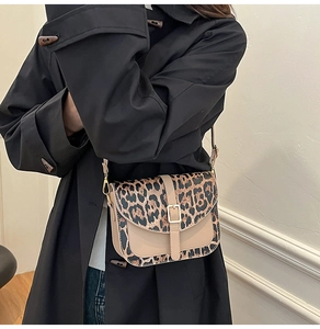 Detail of leopard print flap and beige leather stitching with gold metal buckle closure