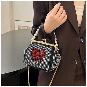 Detailed shot of black rhinestone bag with red heart crystal and pearl bead handle