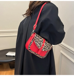 Dettaglio della borsa a tracolla in pelle PU rossa con patta leopardata e fibbia d'oro