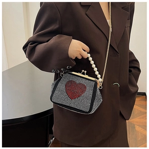 Detail of vintage evening bag with red rhinestone heart, pearl handle and chain strap