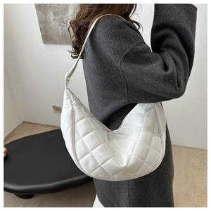 Detailed side view of white quilted hobo bag featuring elegant crescent shape and texture