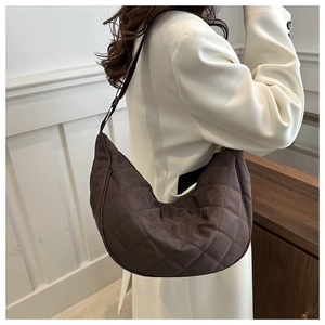 Detail view of coffee quilted crescent shoulder bag with elegant diamond stitching design