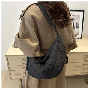 Detailed view of black quilted moon bag with adjustable shoulder strap and nylon texture