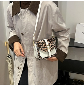 Dettaglio borsa a sella zebrata trendy con fibbia dorata e tracolla regolabile