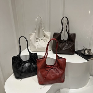 Large woven tote bags with bow details in black, burgundy, beige, and dark brown colors