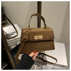Detail view of brown suede mini square bag featuring gold twist lock and adjustable strap