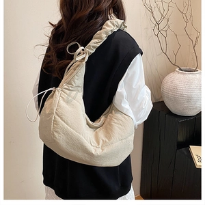 Detalle del bolso de hombro fruncido crema con tejido de nailon y diseño de cordón ajustable