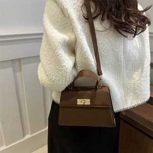 Minimalist dark brown matte leather crossbody bag with elegant gold metal twist lock