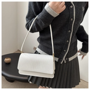 Close-up of a white shoulder bag with woven texture detail and smooth leather finish