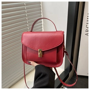 Detailed view of dark red soft synthetic leather with golden metal lock and strap