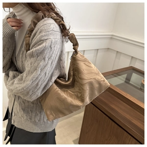 Détail du sac hobo à motif marbre marron avec anse plissée et texture soyeuse lisse