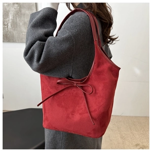 Detailed view of red frosted shoulder bag featuring a large decorative ribbon bow