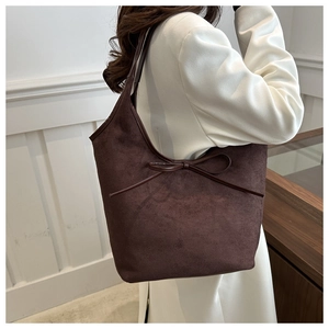 Detail view of large dark brown suede tote bag with elegant bow knot decoration