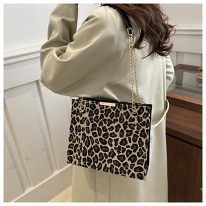 Close-up of leopard print shoulder bag with gold chain strap and textured fabric detail