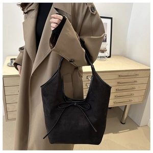 Detail of elegant black frosted tote bag featuring a decorative bow on the front