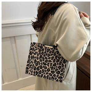 Detailed view of the leopard print fabric texture and gold chain strap on the shoulder bag