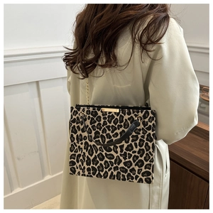Detail shot of leopard print handbag with gold chain strap and black leather handle