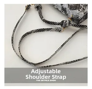 Detail of adjustable strap with gold-tone hardware on snakeskin patterned handbag