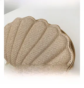 Detailed macro view of woven shell-shaped bag with pearl strap and metal zipper