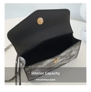 Detail view of snakeskin pattern handbag showing interior space and gold magnetic clasp