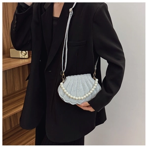 Detail of silver glitter shell bag with large faux pearl handle and metal chain strap