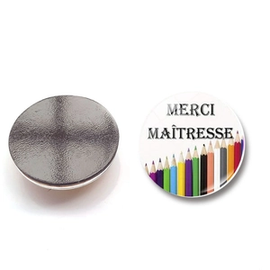 Detail view of round Teachers Day fridge magnet with Merci Maîtresse and pencil design