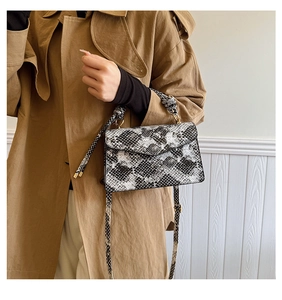Detail of trendy black and white snakeskin pattern texture on chic crossbody square bag