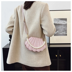 Pink shell-shaped handbag detail featuring pearl chain and shimmering texture