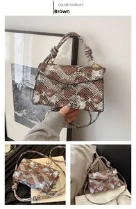 Detail view of brown snake print crossbody bag with knotted handle and golden buckle