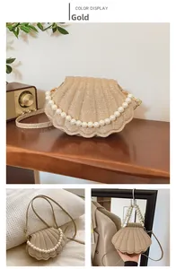 Close-up of gold shell handbag featuring large pearl trim and textured metallic fabric