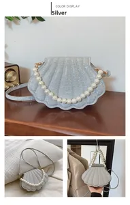 Detailed view of silver shell-shaped bag with glitter finish and pearl top handle