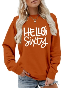 Detalle del estampado Hello Sixty en una cómoda sudadera naranja de cuello redondo