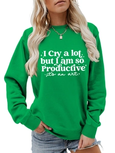 Detail of green crewneck sweatshirt featuring white artistic slogan print and ribbed cuffs