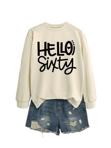 Vista detallada de la sudadera beige Hello Sixty combinada con pantalones cortos vaqueros