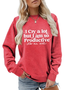 Detailed view of the ribbed crewneck and white text print on a red long sleeve sweatshirt