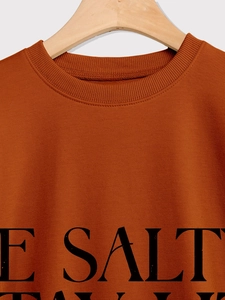 Close-up of caramel oversized sweatshirt with ribbed neckline and bold E SALT print