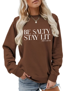 Detail of Be Salty Stay Lit text print on dark brown long sleeve crewneck sweatshirt