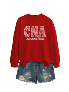 Detail of red crewneck sweatshirt with white leopard print CNA lettering and blue denim shorts