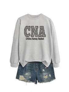 Flat lay of gray CNA Certified Nursing Assistant sweatshirt with leopard print and denim shorts
