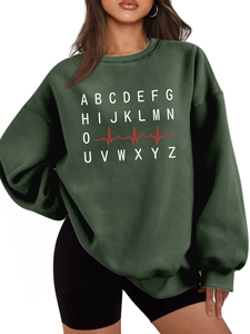 Detail of dark green sweatshirt featuring white letters and red heartbeat graphic print