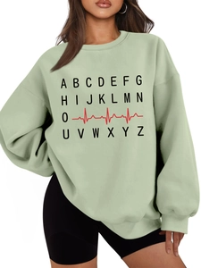 Detail of sage green oversized sweatshirt featuring black letter print and red heartbeat pattern